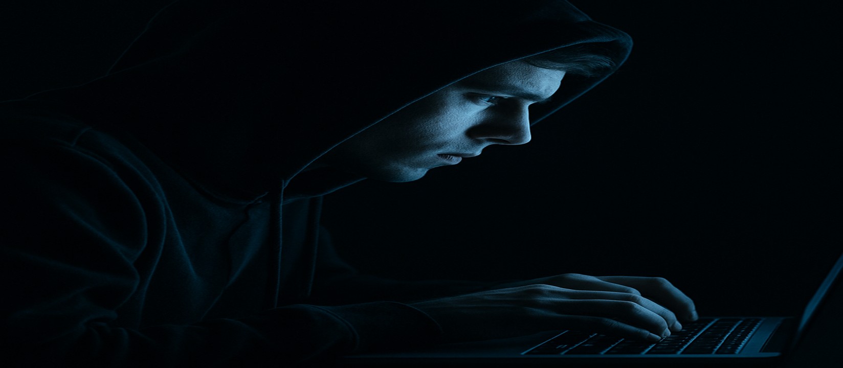 একজন ব্যক্তি cb6 ওয়েবসাইটে অনলাইন গেম খেলার জন্য অন্ধকার একটি কক্ষে ল্যাপটপে মনোযোগ দিয়েছেন